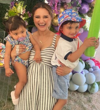 Smiling woman holds two young children