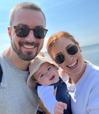 Smiling man and woman hold smiling baby